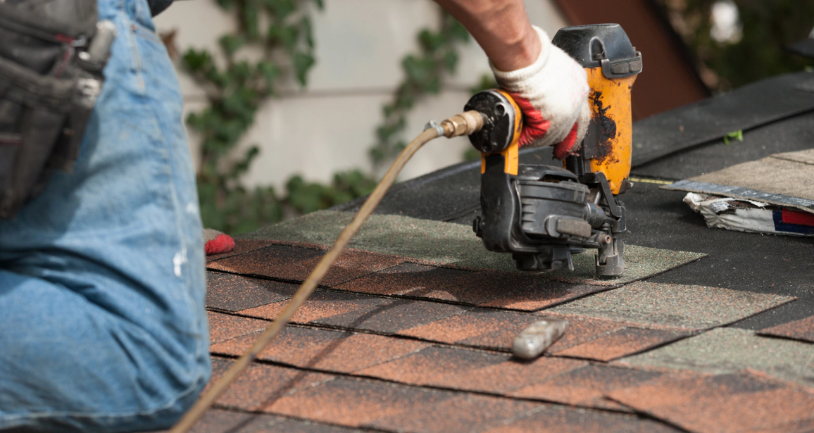 close up shot worker installing asphalt shingles